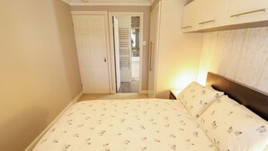 A bedroom with a bed, a nightstand, a lamp, and a wardrobe. - Witham View (Lincoln)