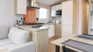 A compact kitchen with a central island, a microwave, and a sink. - Giorgio (Preston)
