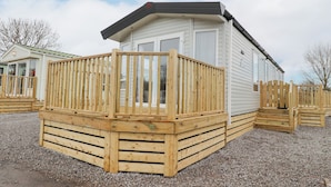 A mobile home with a wooden deck and a small porch. - Giorgio (Preston)