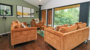 A modern living room with orange sofas, a coffee table, and a fireplace.