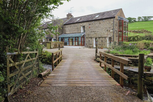 A stone building with a wooden deck leading to a gated entrance. - Beckside Hall (Carnforth)
