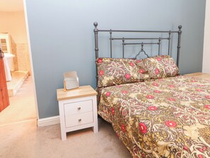 A bedroom with a bed, a bedside table, and a nightstand. - Homestead (High Peak)