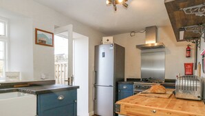 A kitchen with a wooden countertop, a toaster, a refrigerator, and a stove. - Fisherman's Cottage, King Street (Portland)