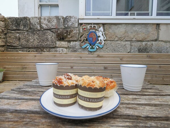 A table with a plate of pastries and two cups on a wooden bench. - Fisherman's Cottage, King Street (Portland)