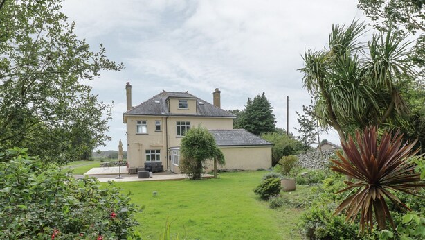Ein zweistöckiges Haus mit gepflegtem Rasen und Garten.