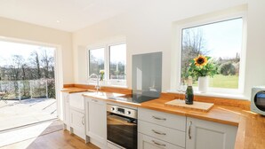 Una cocina moderna con una isla grande, horno empotrado y vistas al exterior.
