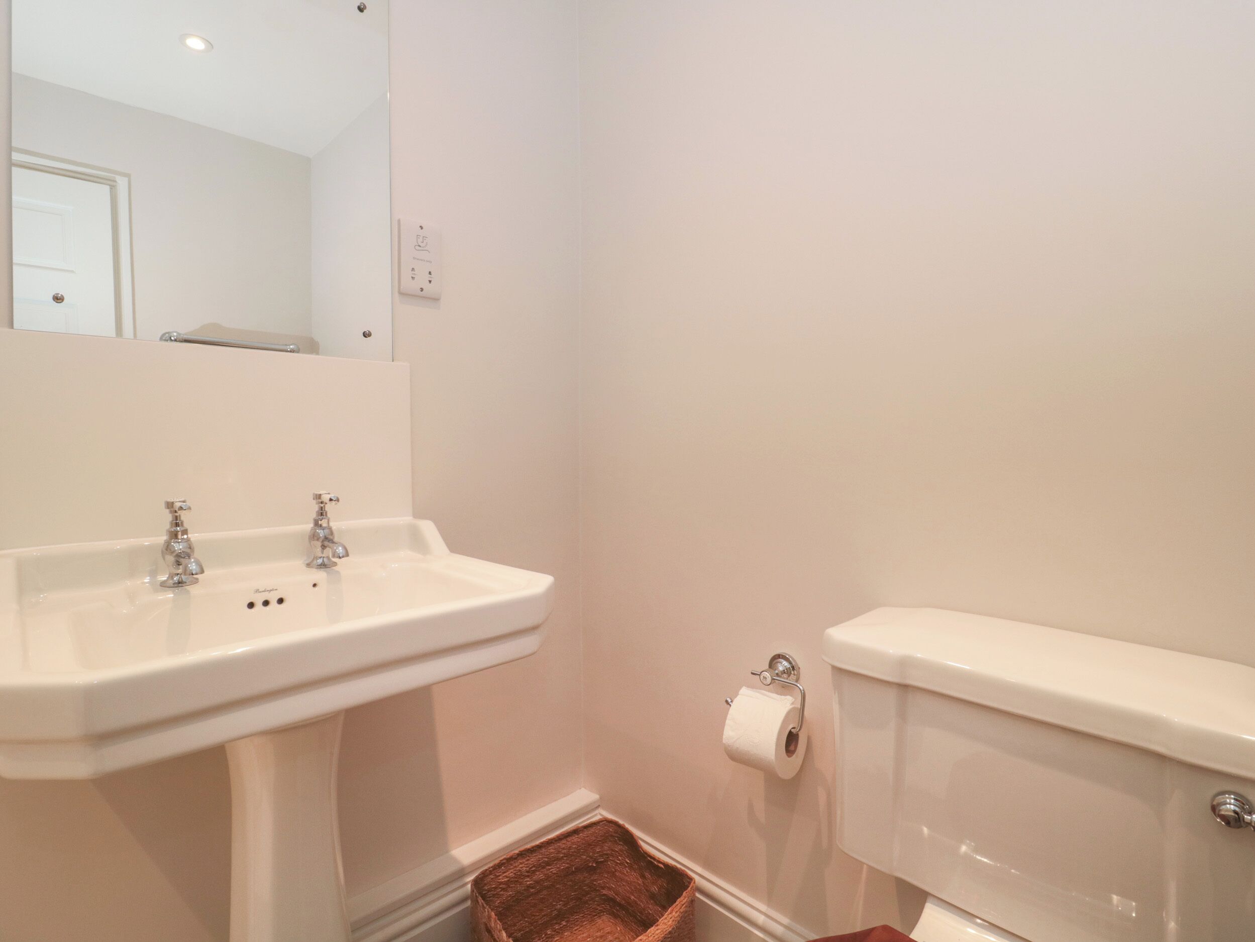 A bathroom with a white sink, a toilet, and a mirror.