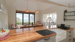Een moderne keuken met een houten aanrecht, een spoelbak en een eethoek met stoelen.