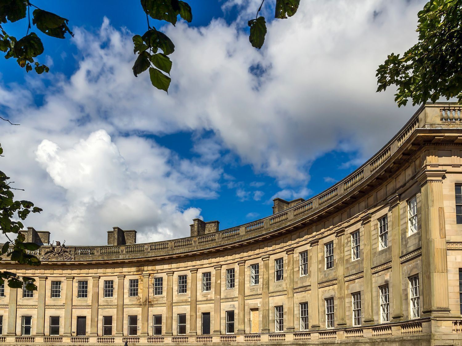 A classical building with a curved facade, large windows, and a prominent central entrance.