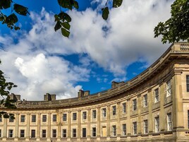 A classical building with a curved facade, large windows, and a prominent central entrance.