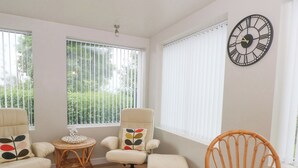 A room with two armchairs, a small round table, and a dining set. - Belle Vue (Stoke-on-Trent)
