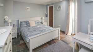 A bedroom with a bed, bedside tables, a dresser, and a mirror. - Quarter Deck (Salcombe)