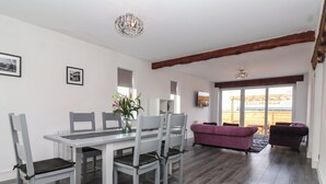 Un coin repas avec une table et des chaises, un canapé violet et un plancher en bois.