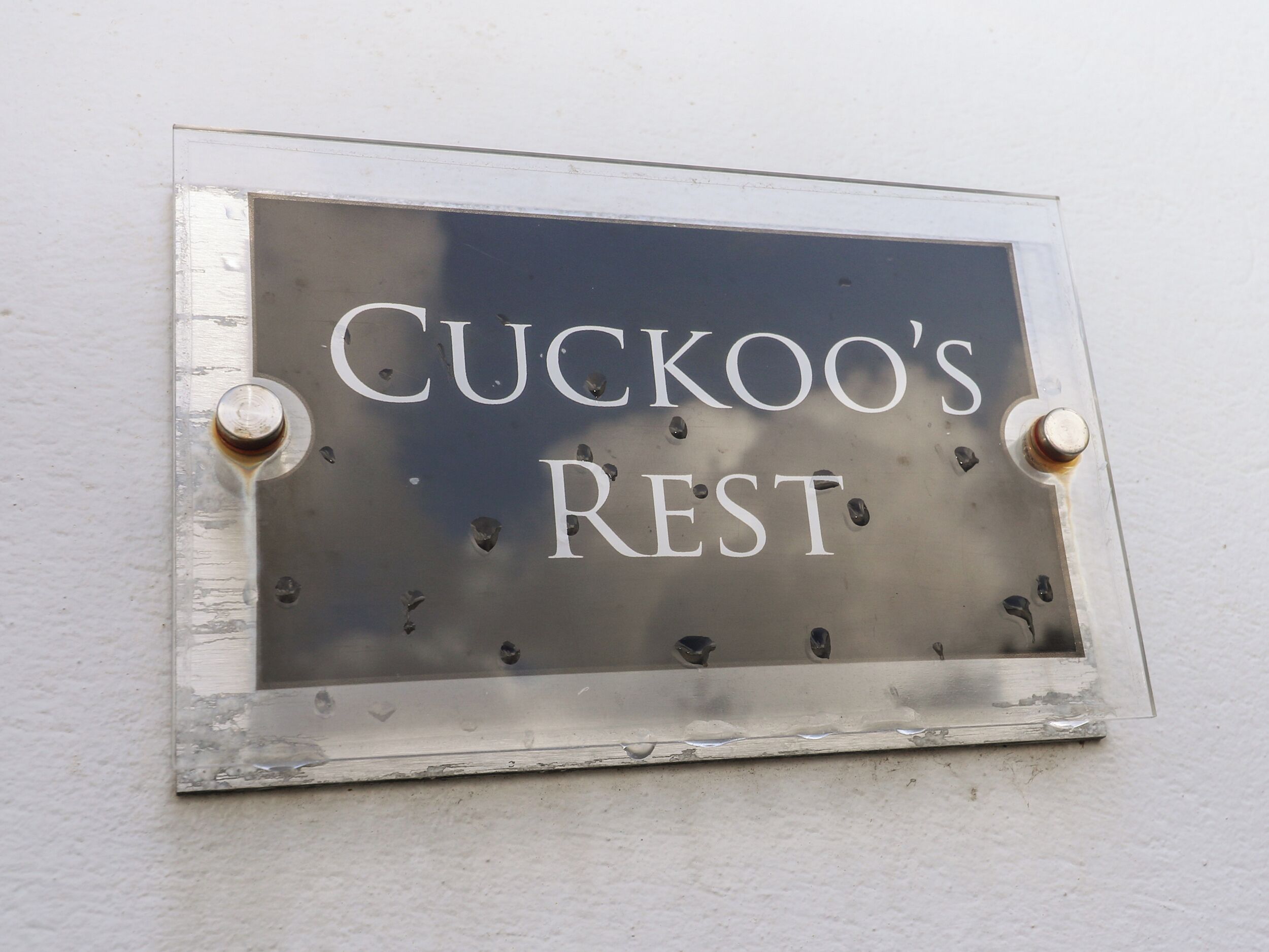 Un letrero con el texto 'CUCKOO'S REST' colgado en una pared.