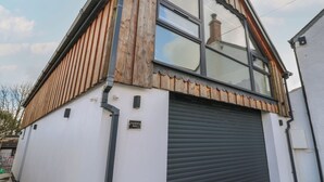 Une maison avec un toit en pente, une grande fenêtre et une porte de garage.