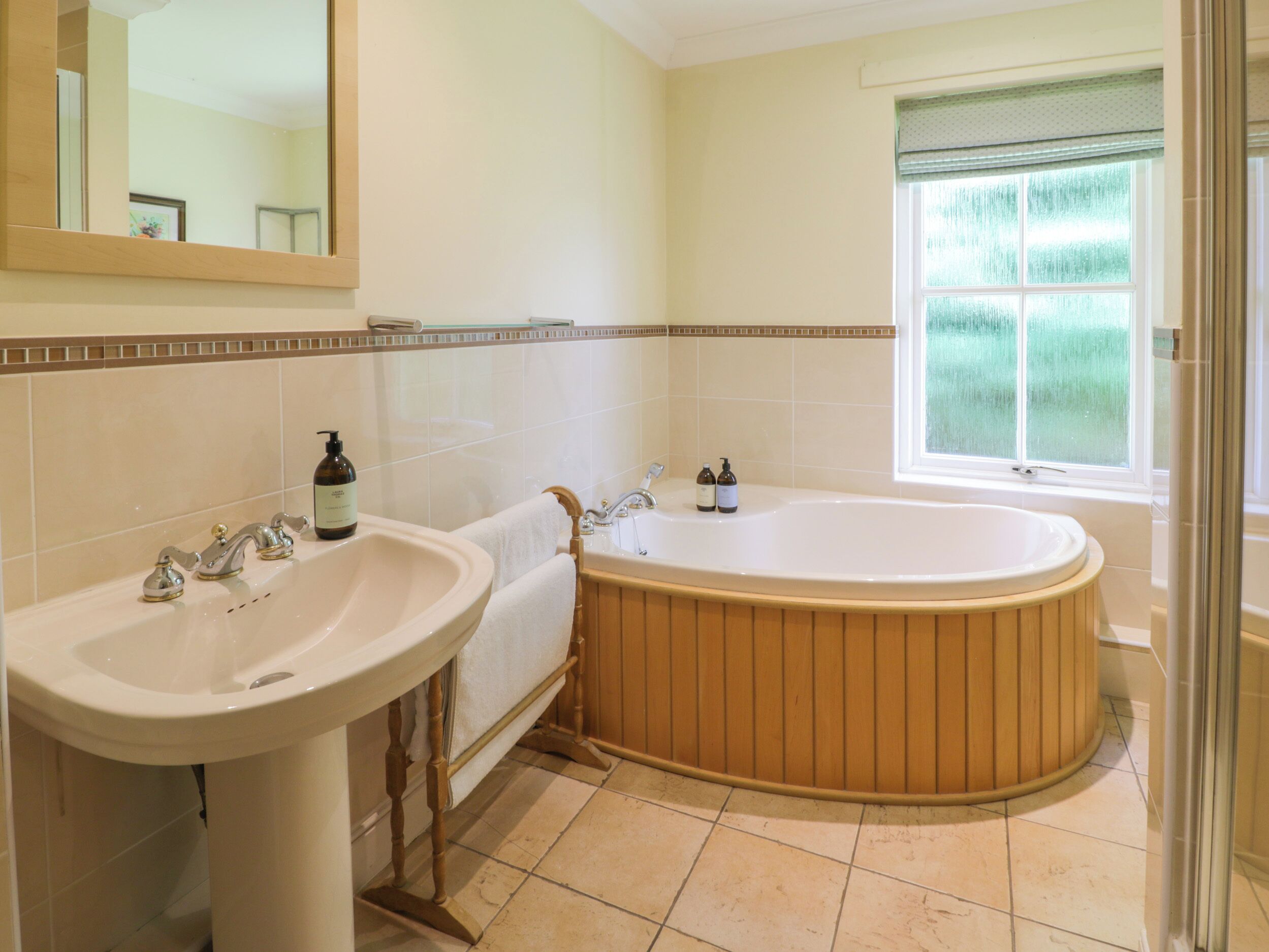 Un bagno con una vasca freestanding, un lavabo e uno specchio.