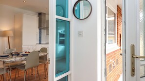 Een eetgedeelte met een tafel voor vier personen, stoelen en een lamp.