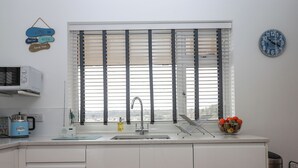 Een moderne keuken met een raam, een spoelbak en een klok aan de muur.