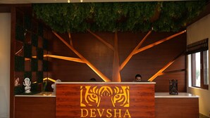 Un mostrador de recepción con detalles de madera y un logotipo que dice "DEVSHA".