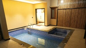 Una piscina con suelo de azulejos y una escalera.