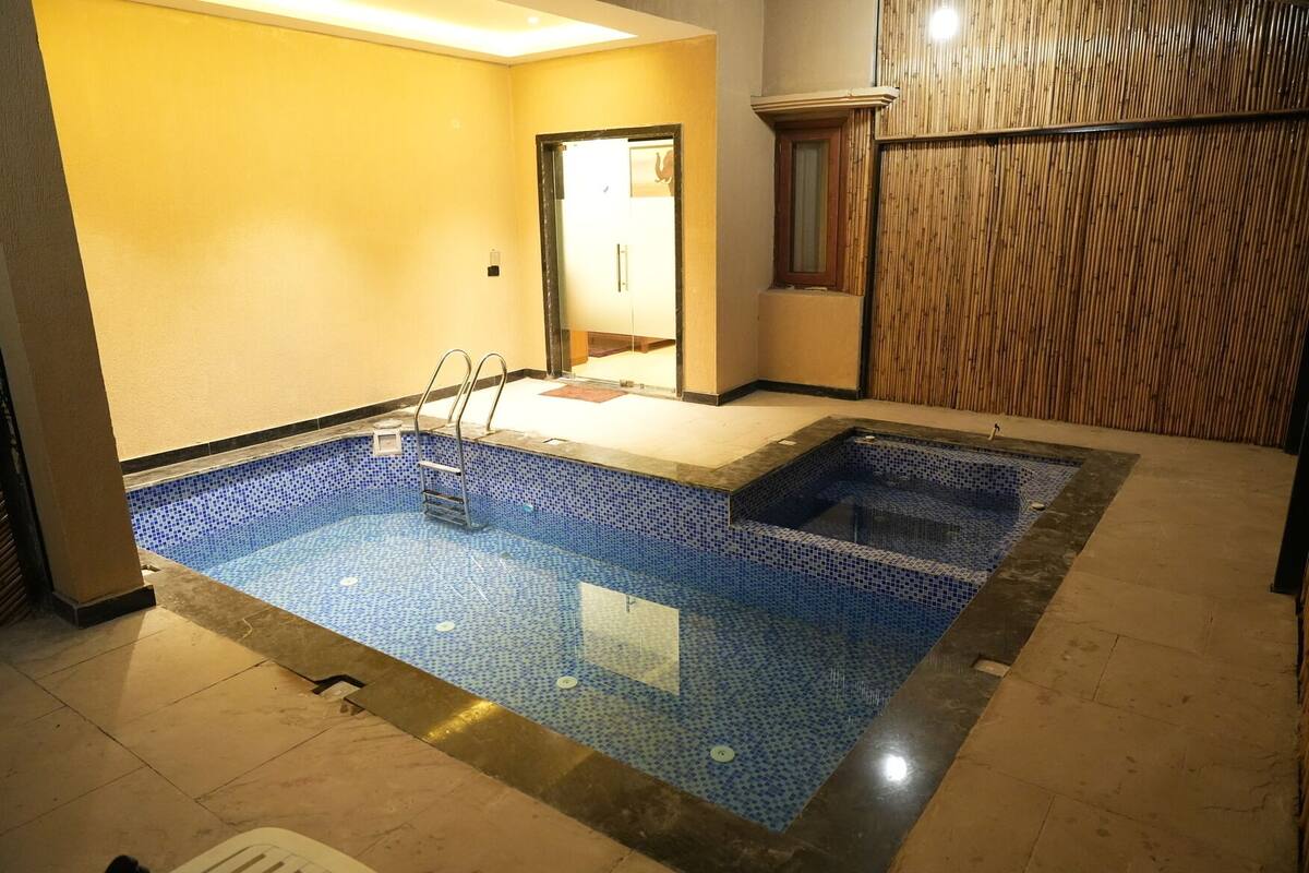 Une piscine avec un sol carrelé et une échelle.