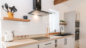 Eine moderne Küche mit weißen Schränken, einer schwarzen Spüle und einem eingebauten Backofen.