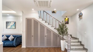 A staircase with a modern design, a blue sofa, and a decorative wall piece.