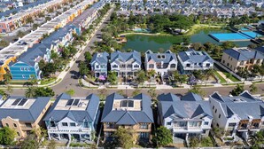 A residential area with houses, a lake, and a Ferris wheel in the background.