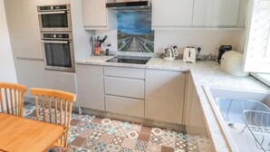 Una cocina compacta con horno integrado, hervidor y tostadora.