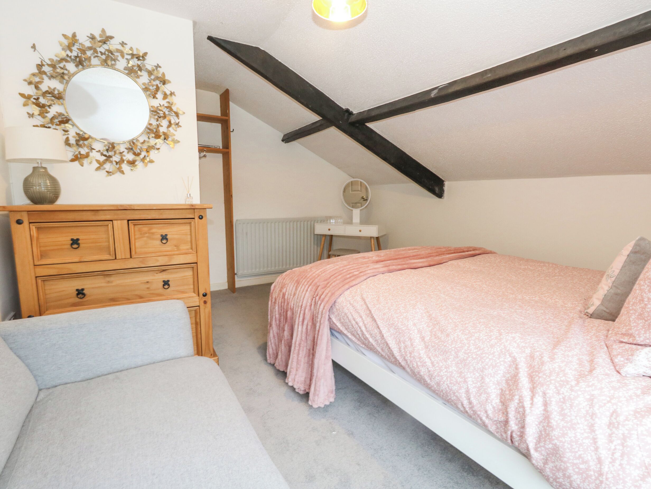 Ein Schlafzimmer mit einem Bett, einem Schminktisch, einem Spiegel und einer Heizung.