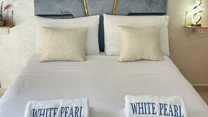 Ein Bett mit zwei Kissen, einem Kopfteil und zwei Wanduhren.