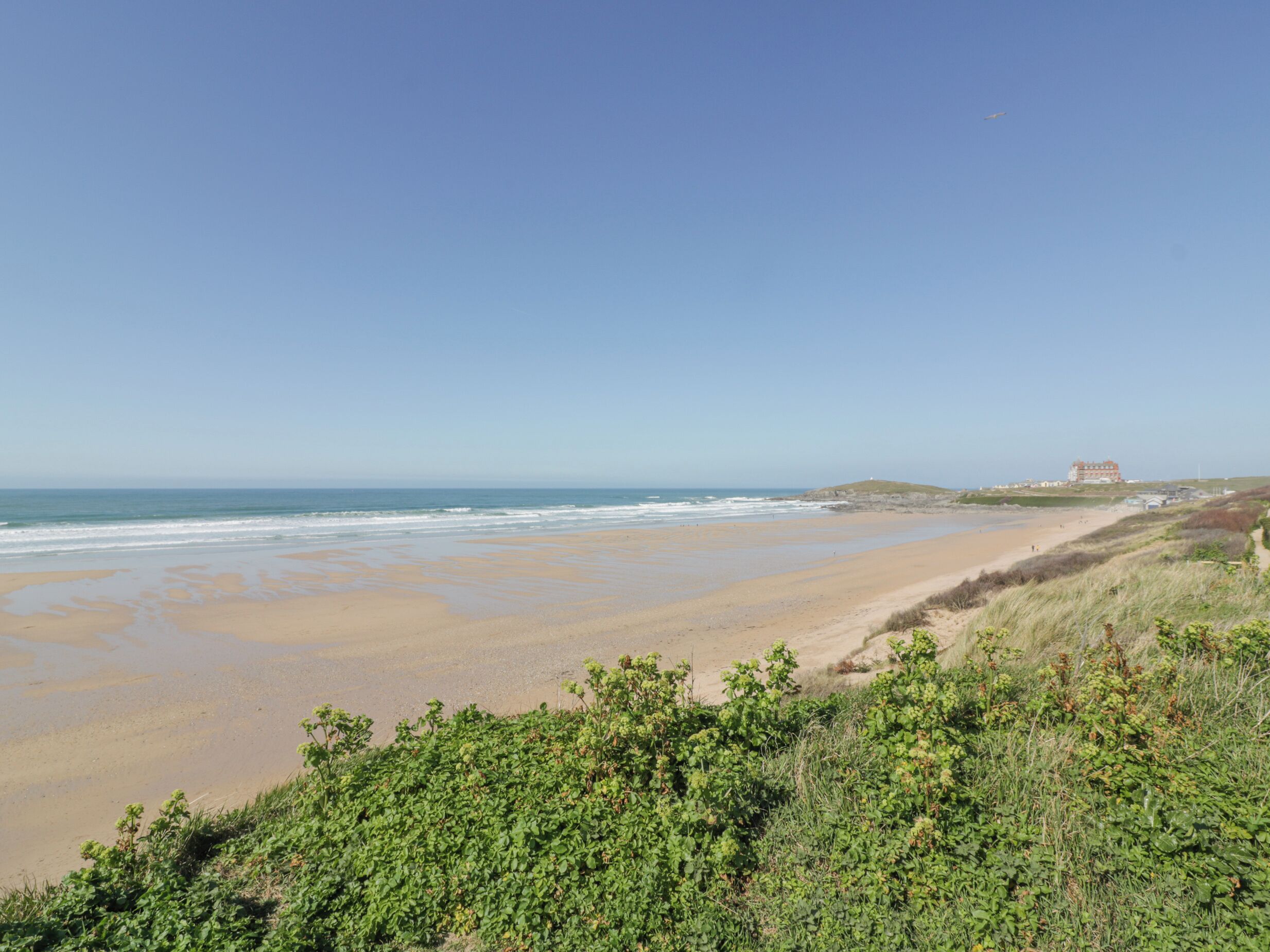 Une plage avec un bâtiment visible au loin.