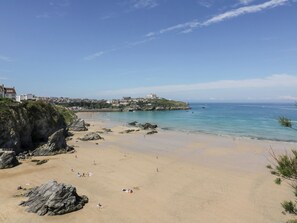 Une plage côtière avec des affleurements rocheux et une vue dégagée sur la mer.