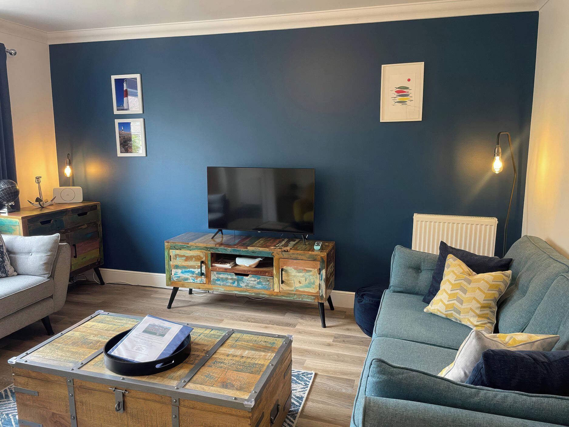 Un salon comprenant un téléviseur, un meuble en bois, un canapé et une table basse.