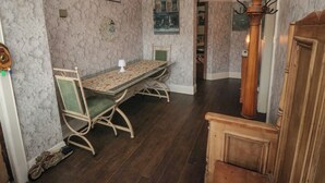 Un espace repas comprenant une table et des chaises, un lustre et un escalier en bois.