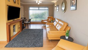 A living room with a sofa, TV, and a fireplace. - 315 Filey Road (Scarborough)