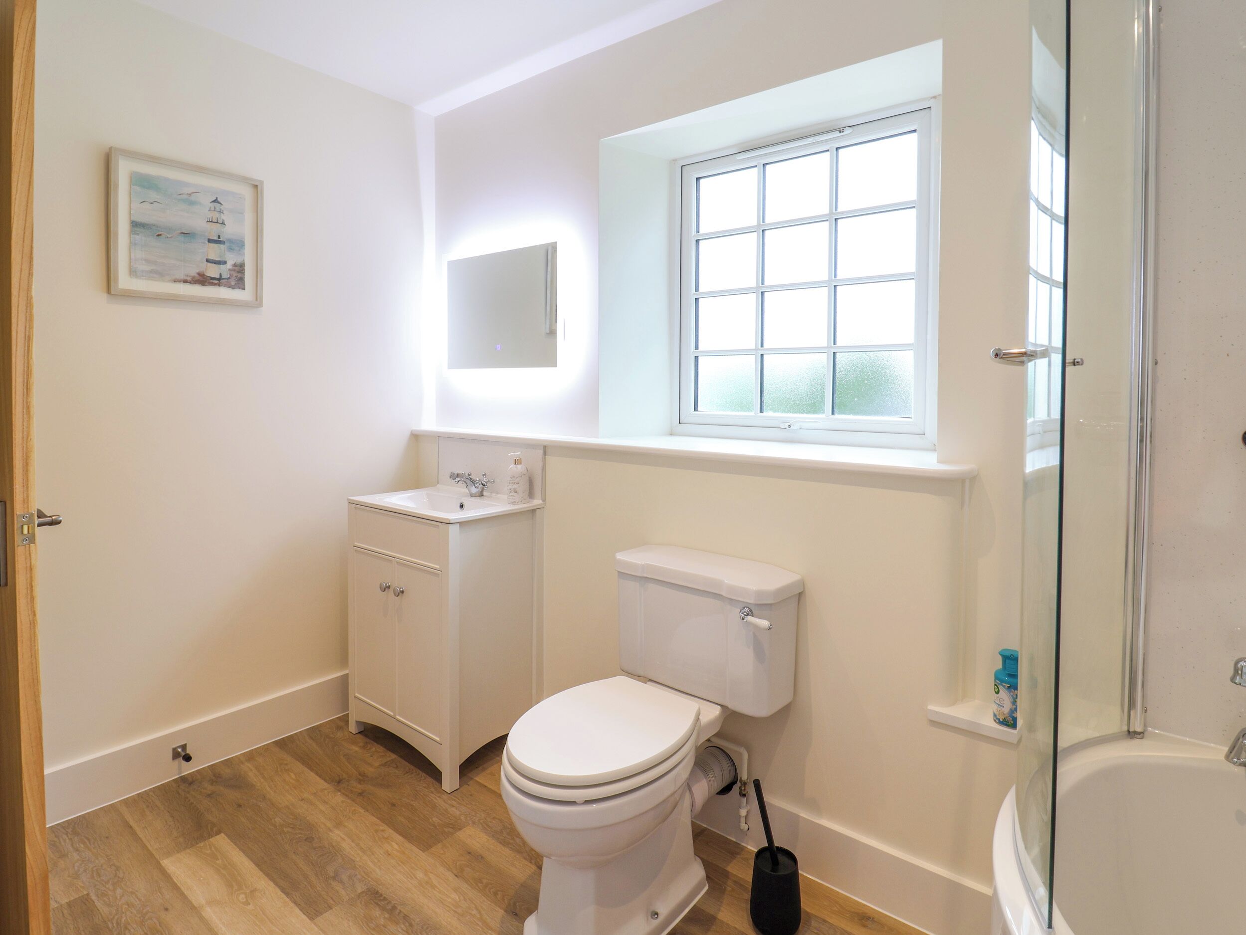 A bathroom with a toilet, sink, and shower.
