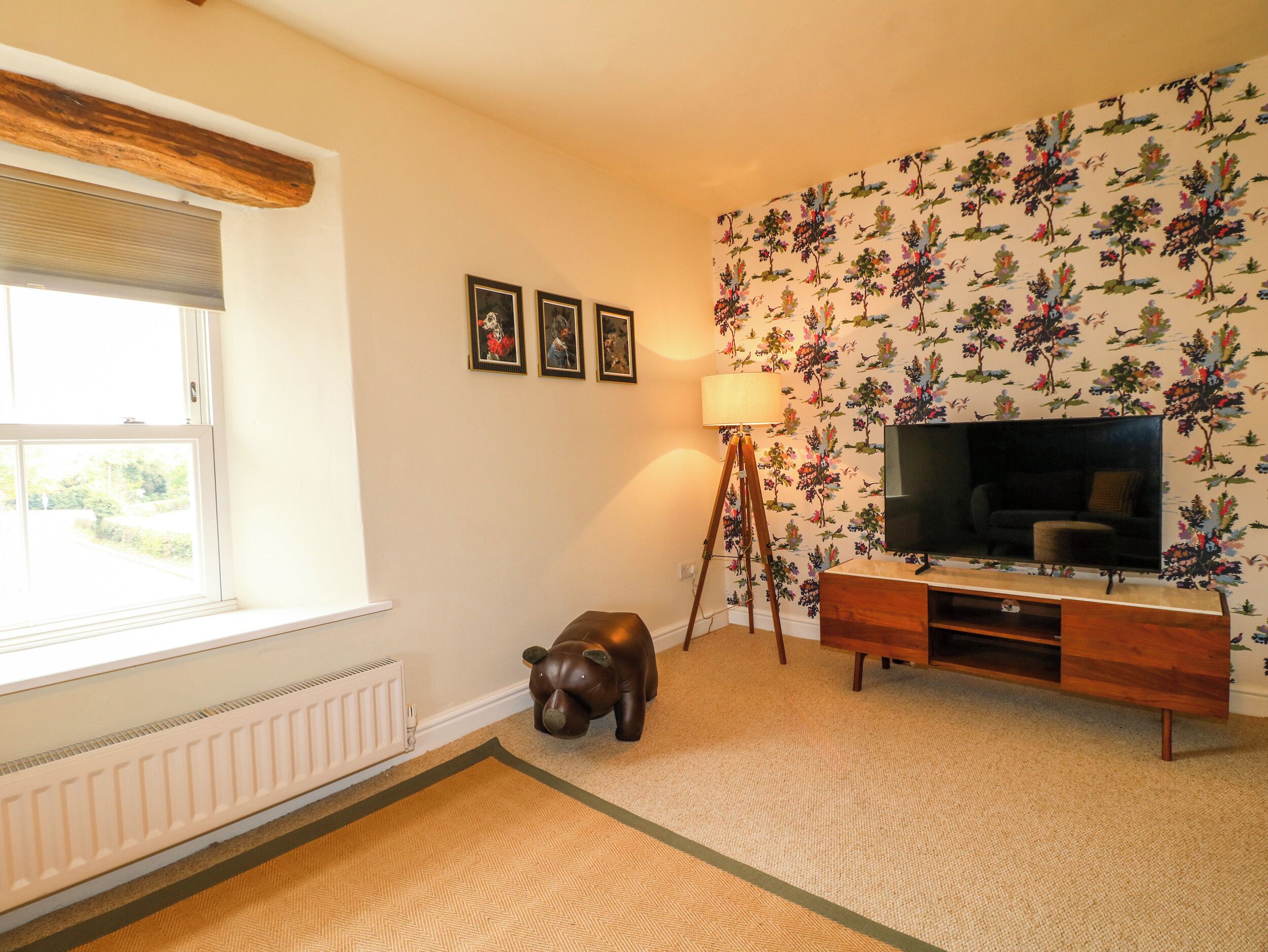 A living room with a television, a lamp, and a small elephant statue.