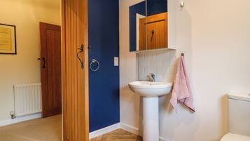 A bathroom with a wooden door, a white sink, and a toilet.