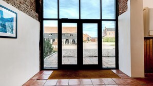 A room with a large window, a doormat, and a framed picture on the wall. - Coot (Beccles)