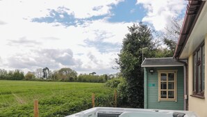 Boblebad i en have med udsigt over et mark og en lille bygning.