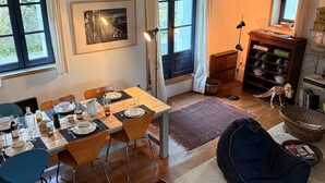 A dining area with a wooden table set for four, a blue chair, and a bean bag chair. There is a bookshelf with books and a skeleton model. - Charming house, Close to Geneva, Annecy, ski slopes, at the foot of the Salève mountains (etrembiers)