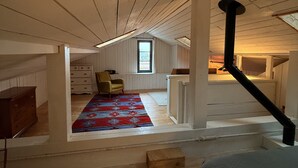 A loft-style room with a wooden ceiling, a staircase, a window, and a colorful rug. - Charming house, Close to Geneva, Annecy, ski slopes, at the foot of the Salève mountains (etrembiers)