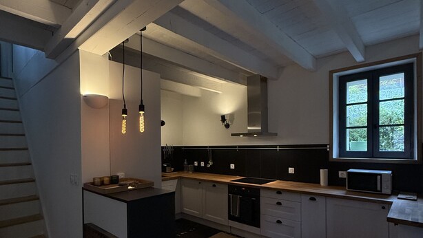 A modern kitchen with a central island, built-in appliances, and pendant lighting. - Charming house, Close to Geneva, Annecy, ski slopes, at the foot of the Salève mountains (etrembiers)