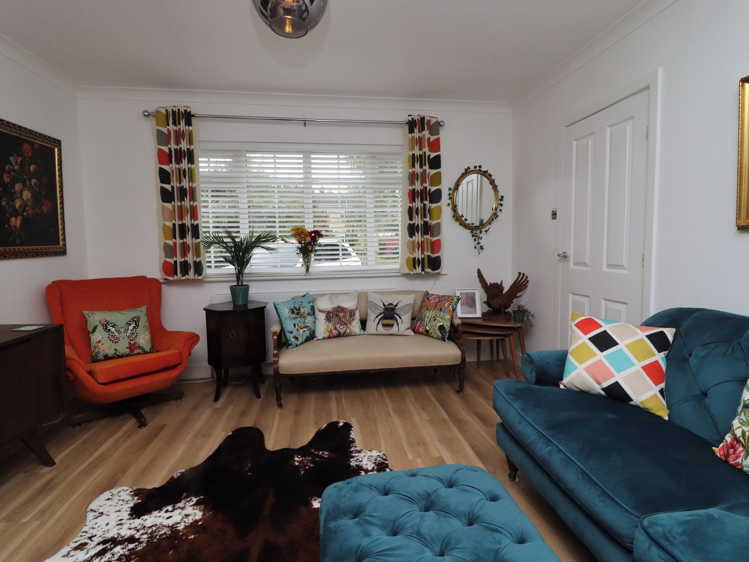 A living room with a sofa, armchair, and a rug.