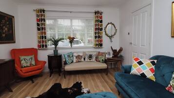 A living room with a sofa, armchair, and a rug.