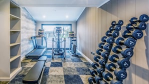 A home gym with a treadmill, elliptical, and free weights. - Chalet 2 at Landscove Holiday Park (Brixham)