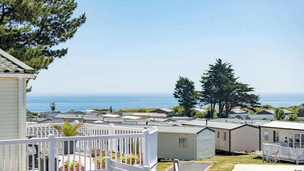 A row of mobile homes with a view of the ocean. - Chalet 11 at Landscove Holiday Park (Brixham)