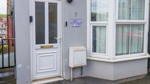 Esquina de un edificio con una puerta blanca, un letrero que indica vistas panorámicas y un pequeño cuadro eléctrico.