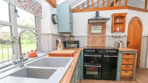 Una cucina con lavello, due forni, un tostapane e un piano di lavoro in legno.